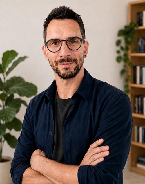 Damien Gros, expert Drupal et PHP, bras croisés devant une bibliothèque